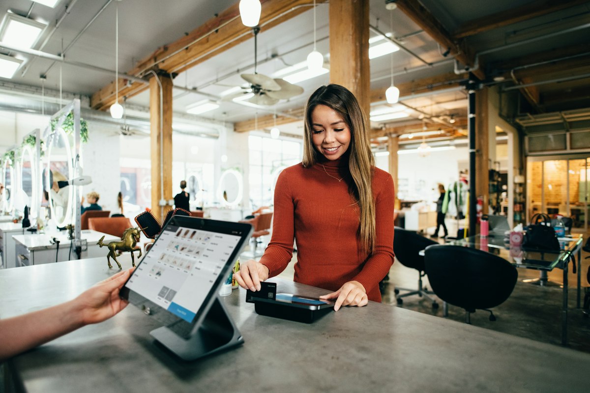 Small business owner completing a card payment transaction at a shop counter